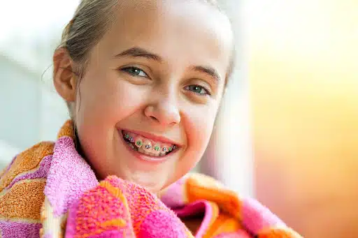 Smiling child wearing braces showing healthy tooth development with kids' braces tooth development
