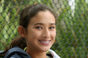 Teen girl smiling outdoors with braces showing confidence and active braces for teens lifestyle